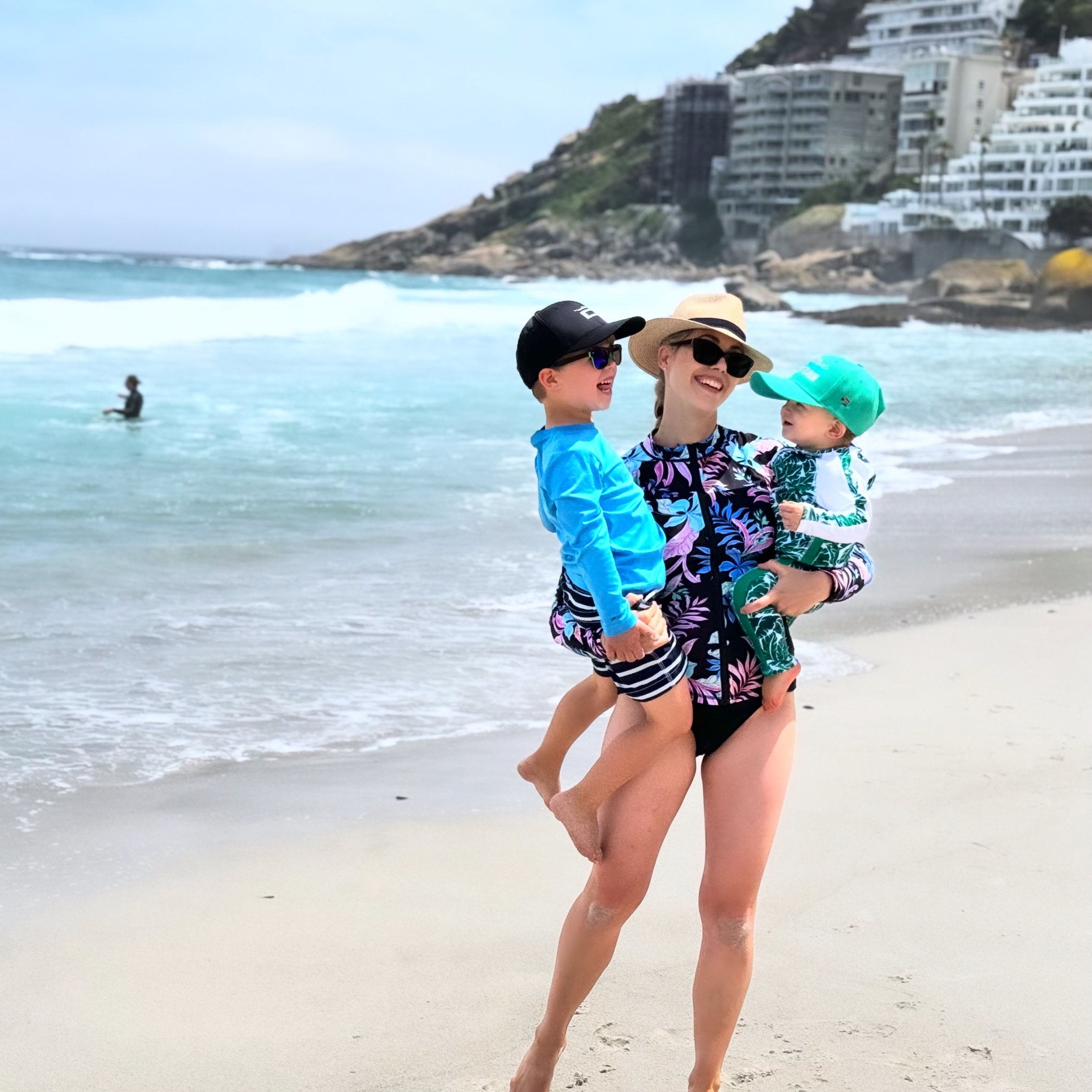 A parent and two children enjoying a sunny family beach day
